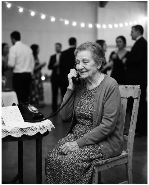 Grand-mère laissant un message dans un téléphone à cadran lors d'un mariage